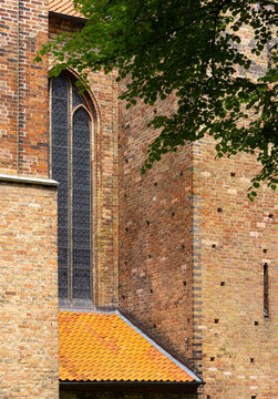 Historic Brick Church with Gothic Window and Red Tiled Roof Detail
