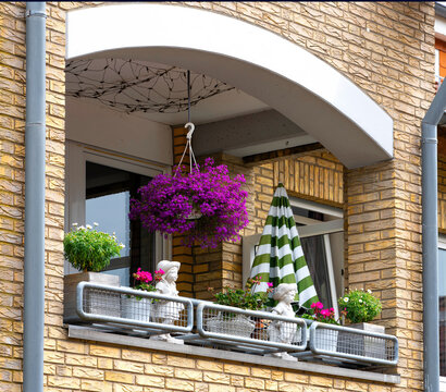 Cozy Balcony with Hanging Flowers and Decorative Plants on Brick House