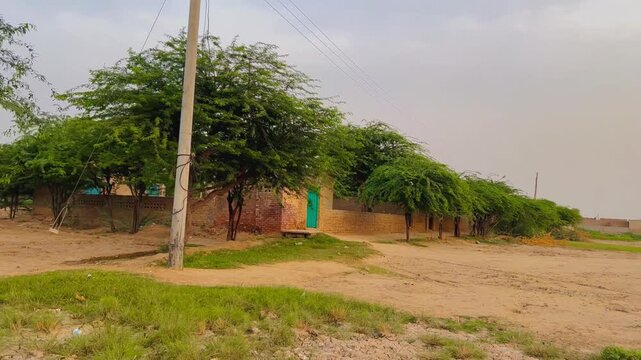 Rural village house with green door. Traditional mud brick home in a desert landscape.