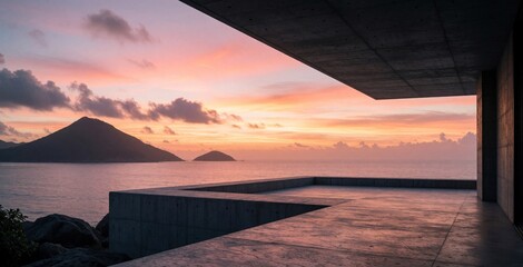 Obraz premium Concrete modern building terrace overlooking sea ocean horizon during vibrant colorful sunset. Minimalist architectural villa platform faces calm water waves with distant mountain silhouette islands.