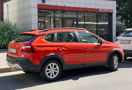 New Lada Iskra Cross hatchback produced in Tolyatti parked on street. Side view of bright orange Russian vehicle outdoor presentation background. Domestic automotive industry news editorial product. 