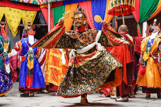 Bhutan, In the village of Bumthang,a monk in colorful costumes dances during the Jakar festival.
