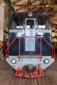 Panevezys, Lithuania - 19 September 2020: View of the Aukstaitija narrow gauge railway locomotive parked inside a historic depot with red railings and industrial details.