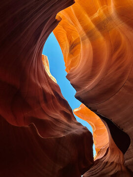 Coconino County, Arizona, United States - 30 July 2026: View of Antelope Canyon with its smooth, flowing sandstone walls and a narrow sliver of bright blue sky.