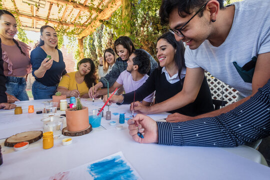 large group of latin people in painting classes in a terrace outdoors in Mexico Latin America, multi generational Hispanic and diverse team meeting in art classes 