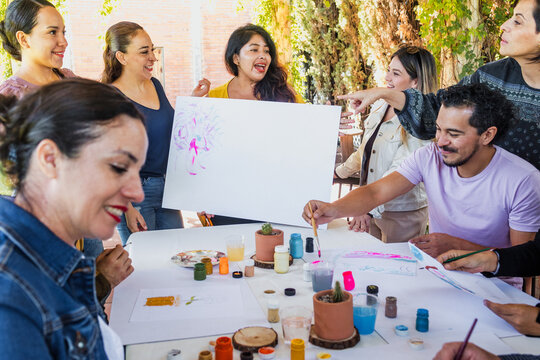 large group of latin people in painting classes in a terrace outdoors in Mexico Latin America, multi generational Hispanic and diverse team meeting in art classes 
