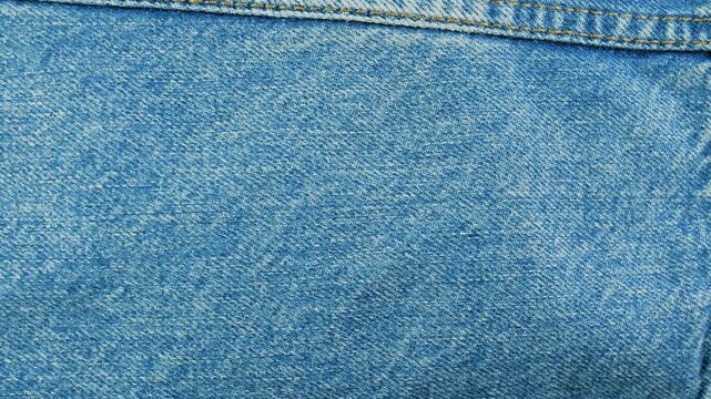 Light blue denim fabric texture with seams background