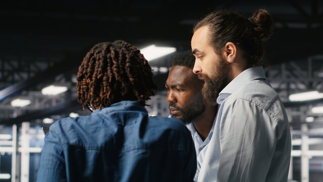 Stressed technicians in server room fighting each other after detecting hacking attempt targeting critical systems, highlighting cybersecurity awareness.