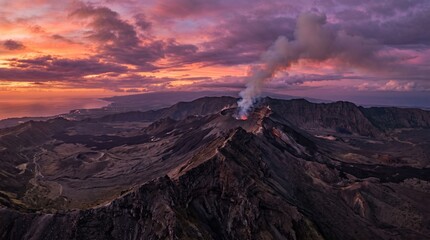 Fototapeta premium Active volcano erupts at sunset, dense smoke and ash rising into a dramatic twilight sky over rugged mountains, a powerful display of nature