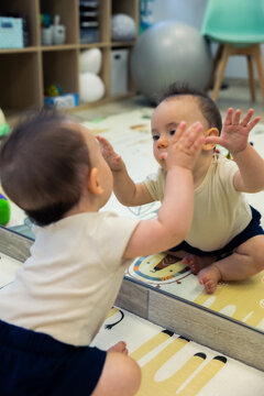 Curious baby discovering reflection in a mirror