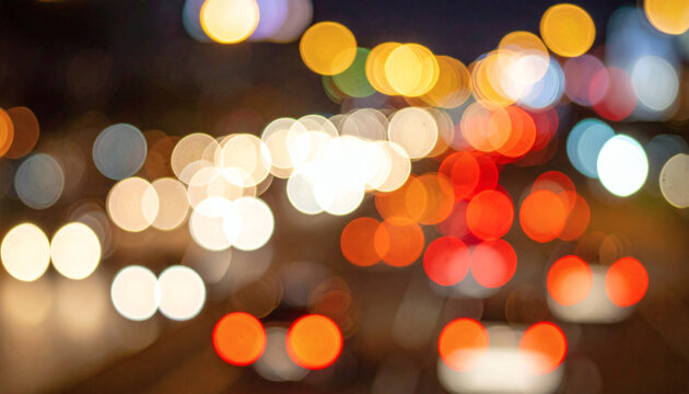 Blurred traffic lights creating colorful circular bokeh patterns on a dark night city street background for modern graphic design projects