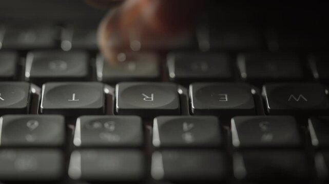 Close-up timelapse male hands typing rapidly on keyboard with motion blur, camera smoothly slides parallel to keys. Dynamic footage of remote work, business activity and digital workflow at night