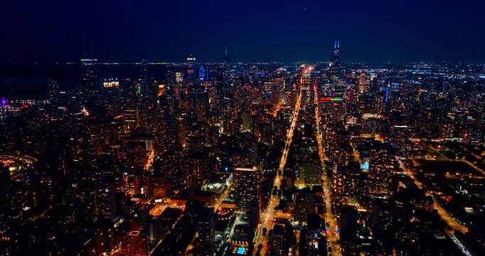 Vast scenery of modern Chicago, Illinois, USA at night. Gorgeous lights of the city downtown from drone footage.
