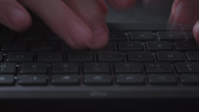 Close-up timelapse male hands typing rapidly on keyboard with motion blur, camera smoothly slides parallel to keys. Dynamic footage of remote work, business activity and digital workflow indoors