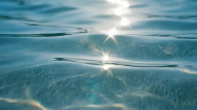 Sparkling sunlight dancing on gentle ocean water surface with sun reflections and peaceful ripples