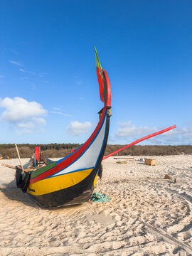 Colorful Arte Xavega wooden fishing boat on sandy beach Furadouro
