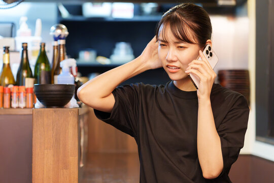居酒屋で電話対応をする女性店長