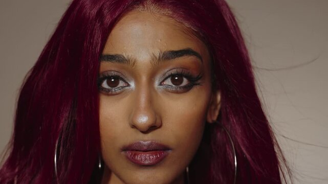 Close-up portrait of young woman with red hair and hoop earrings