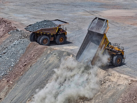Haul Truck Dumping Waste Rock with a Dense Dust Cloud at a Mine Waste Dump