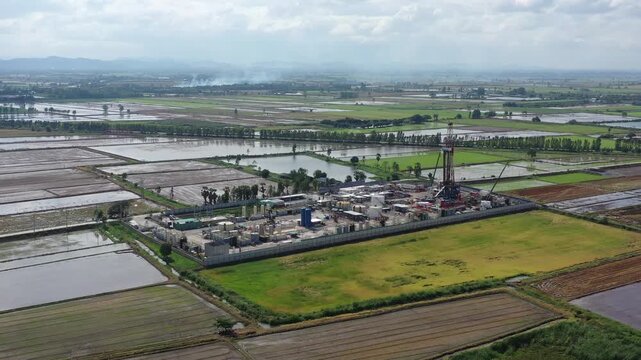 Aerial View of Land Drilling Rig and Oilfield Facility in Rice Fields