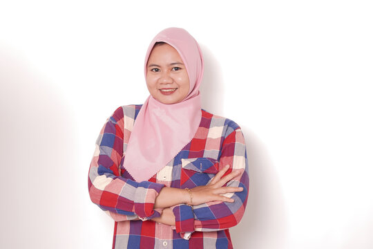 Young Asian Muslim woman wearing pink hijab smiling with arms crossed isolated on white background
