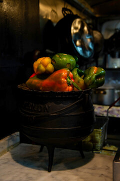 Fresh bell peppers and vegetables in cast iron cauldron pot