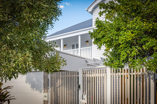 Queenslander house, house exterior, modern home, tropical garden, white house, timber cladding, residential architecture, Australian home, Queensland, veranda, balcony, front gate, contemporary design