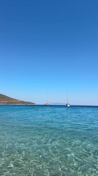 Palamutb&uuml;k&uuml; Dat&ccedil;a, endless deep blue sea, crystal-clear water, sailboat near the shore, rocky Mediterranean coastline, serene summer atmosphere