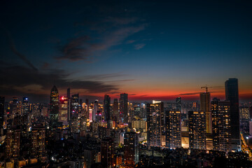 Fototapeta premium Aerial twilight view of Wuhan Financial Street CBD. The towering, illuminated skyscrapers reflecting in the water symbolize the dynamic growth of China's economy.