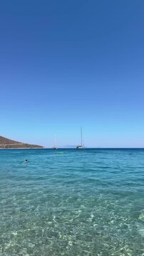 Palamutb&uuml;k&uuml; Dat&ccedil;a, endless deep blue sea, crystal-clear water, sailboat near the shore, rocky Mediterranean coastline, serene summer atmosphere