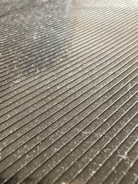 Close up texture of dust layer and lint fibers on a ribbed plastic corrugated surface, abstract grunge overlay background.