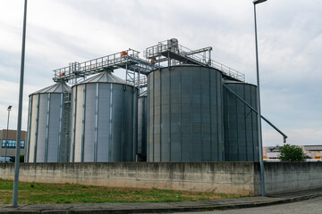 Grain storage silos at agricultural facility, metal cereal silos for wheat and corn, modern farming infrastructure, agribusiness logistics, food supply chain, harvest storage and industrial  © rikstock
