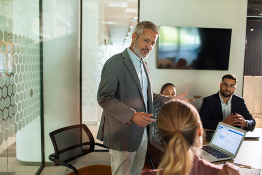 Senior manager leading team meeting in modern office