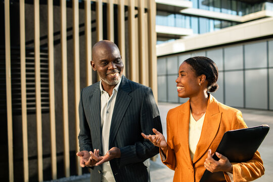 Two business professionals talking outside modern office