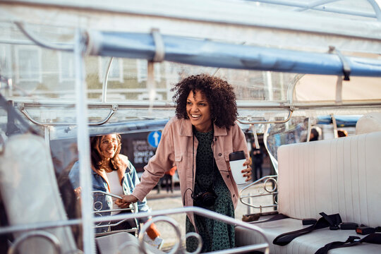 Friends boarding an open-air tour vehicle in the city