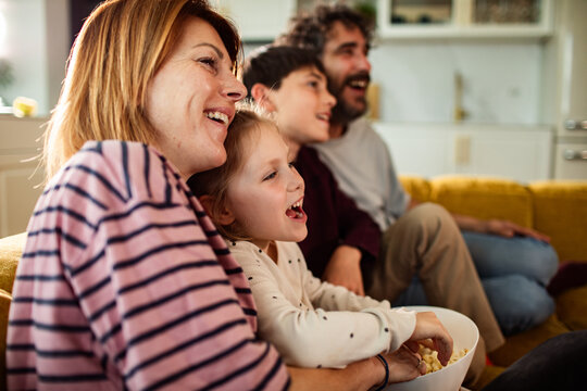 Happy family watching a movie on couch at home