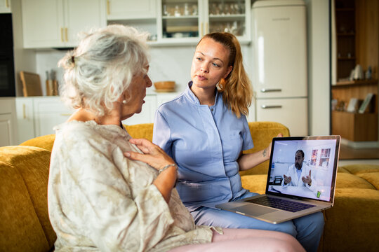 Caregiver and senior woman on telehealth video call at home