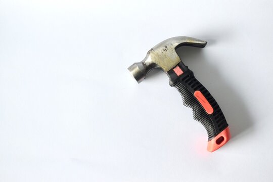 High angle view of a small stubby claw hammer with an ergonomic black and orange rubberized grip handle isolated on a seamless white background.