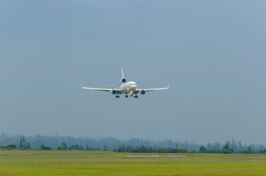White MD-11F cargo plane landing at Mariscal Sucre Airport on a cloudy day