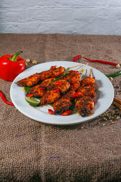 Grilled Squid Skewers with Padang Spices on Banana Leaf

Description
Skewered grilled squid coated in a rich reddish brown Padang style spice glaze rests on a fresh banana leaf atop a white plate, gar