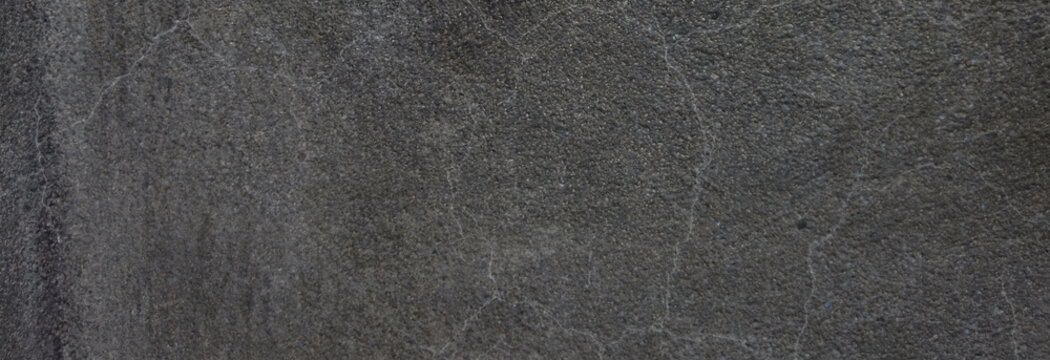 Dark charcoal slate texture background, natural black stone surface with fine cracks, industrial gray concrete wall finish for architectural design