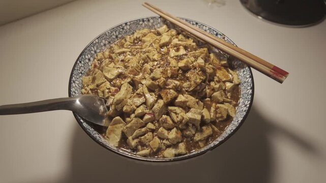 Close Up Bowl of Vegetarian Mapo Tofu with Sichuan Spices and Rich Sauce