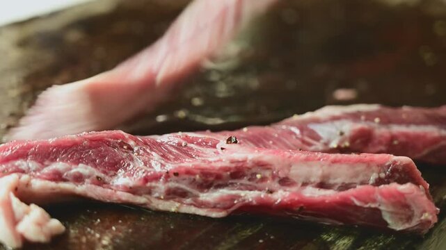 Seasoning Fresh Beef Strips with Salt on Wooden Cutting Board Before Cooking