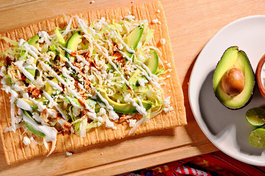 Authentic Mexican street food chicharron preparado served on a wooden board. Direct flash light