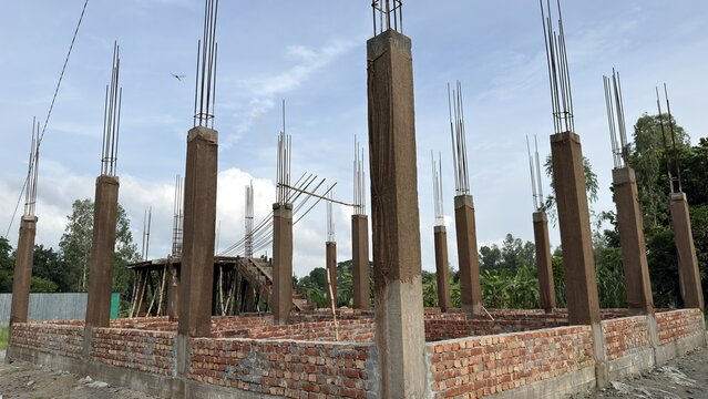 Building structure under construction with concrete pillars and brick foundation