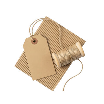 Blank brown cardboard price tag with rustic twine spool isolated on transparent background