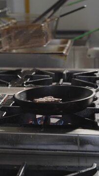 Traditional kofta meatballs cooking in a frying pan.