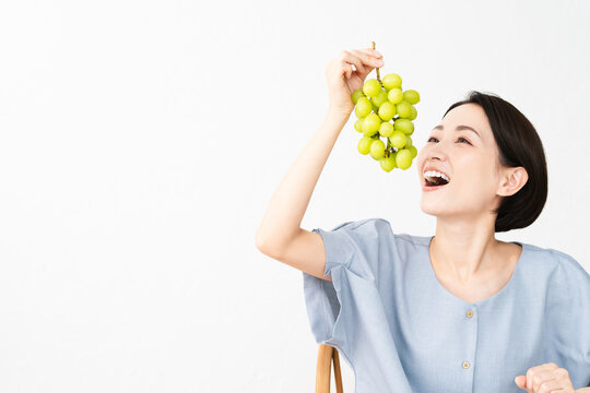 シャインマスカットを食べる女性　食べ物イメージ
