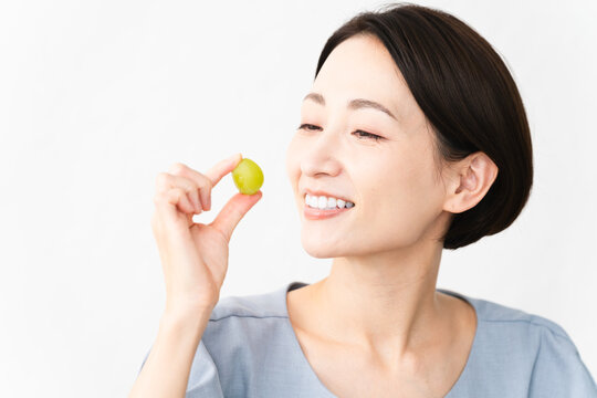 シャインマスカットを食べる女性　食べ物イメージ