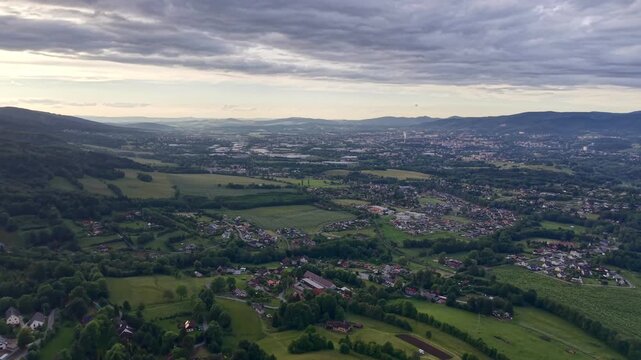 Aerial landscape no visible action static scene, in open countryside with rolling hills and scattered settlements, with hills, fields, settlements, from a aerial perspective perspective.